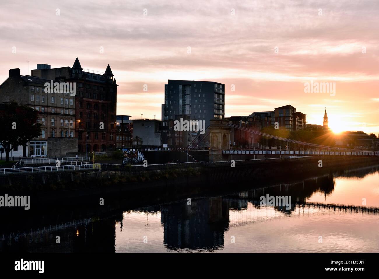 Glasgow, Scotland, Regno Unito. 4 Ottobre, 2016. Regno Unito meteo. Il Broomielaw e Carlton posto ponte di sospensione di sunrise. Credito: Tony Clerkson/Alamy Live News Foto Stock