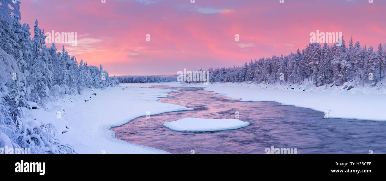 Un rapido in un fiume in un paesaggio invernale. Fotografato alla Äijäkoski rapide nel fiume Muonionjoki in Lapponia finlandese a su Foto Stock
