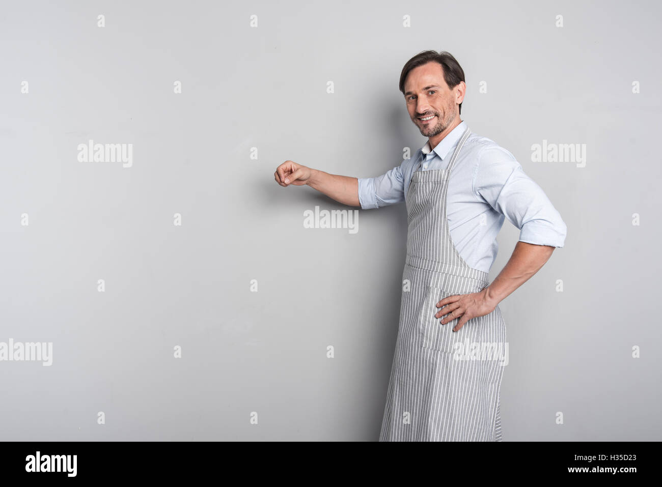 Bello gioiosa giovane uomo gesticolando in un grembiule Foto Stock Bello gioiosa giovane uomo gesticolando in un grembiule Foto Stock