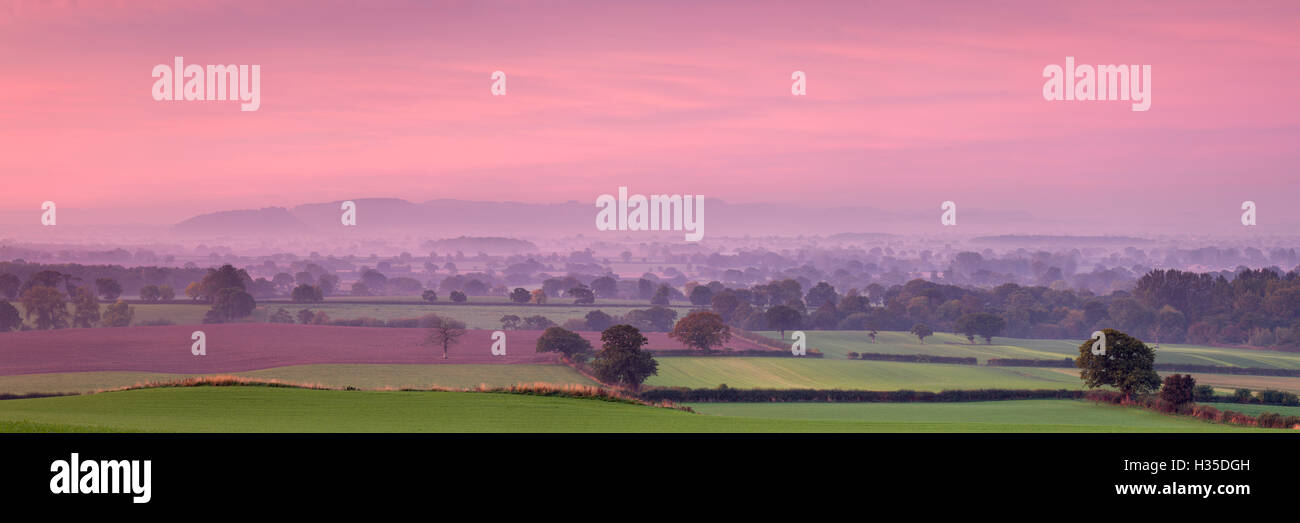 Autunno alba in tutta la pianura del Cheshire con Beeston Castle e le colline Peckforton rientranti nella nebbia mattutina, Cheshire, Regno Unito Foto Stock