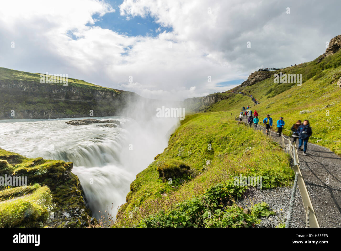 I turisti che visitano Gullfoss (Golden cade), una cascata si trova nel canyon del fiume Hvita nel sud-ovest dell'Islanda Foto Stock