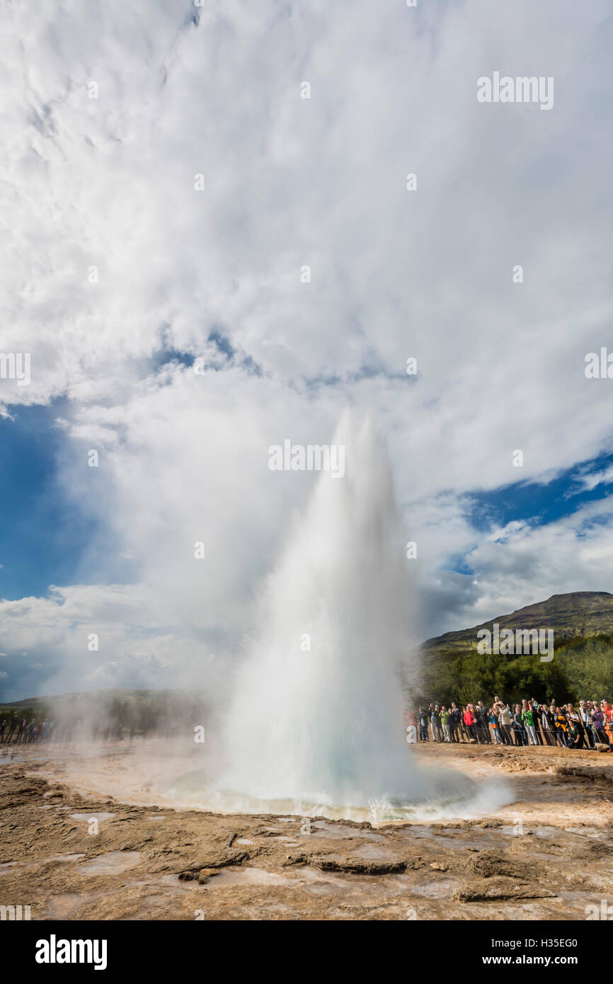 I turisti si riuniscono per guardare Strokker geyser (geysir), un eruzione a molla Haukadalur, Islanda, regioni polari Foto Stock