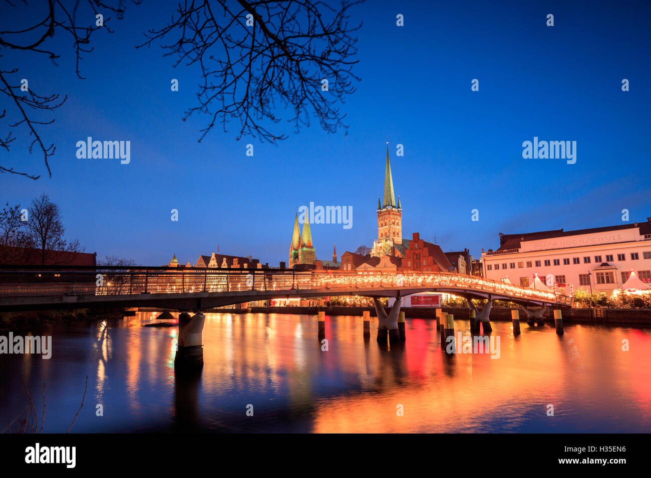 Le luci del tramonto su tipico bridge e la cattedrale si riflette nel fiume Trave, Lubecca, Schleswig Holstein, Germania Foto Stock