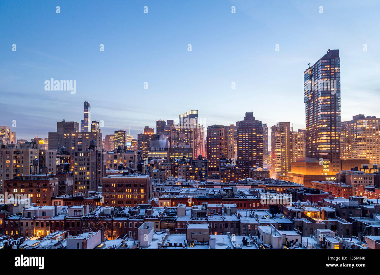 Tetti innevati e Midtown Manhattan al tramonto, visto dalla 72esima strada sulla Upper West Side di New York. Foto Stock