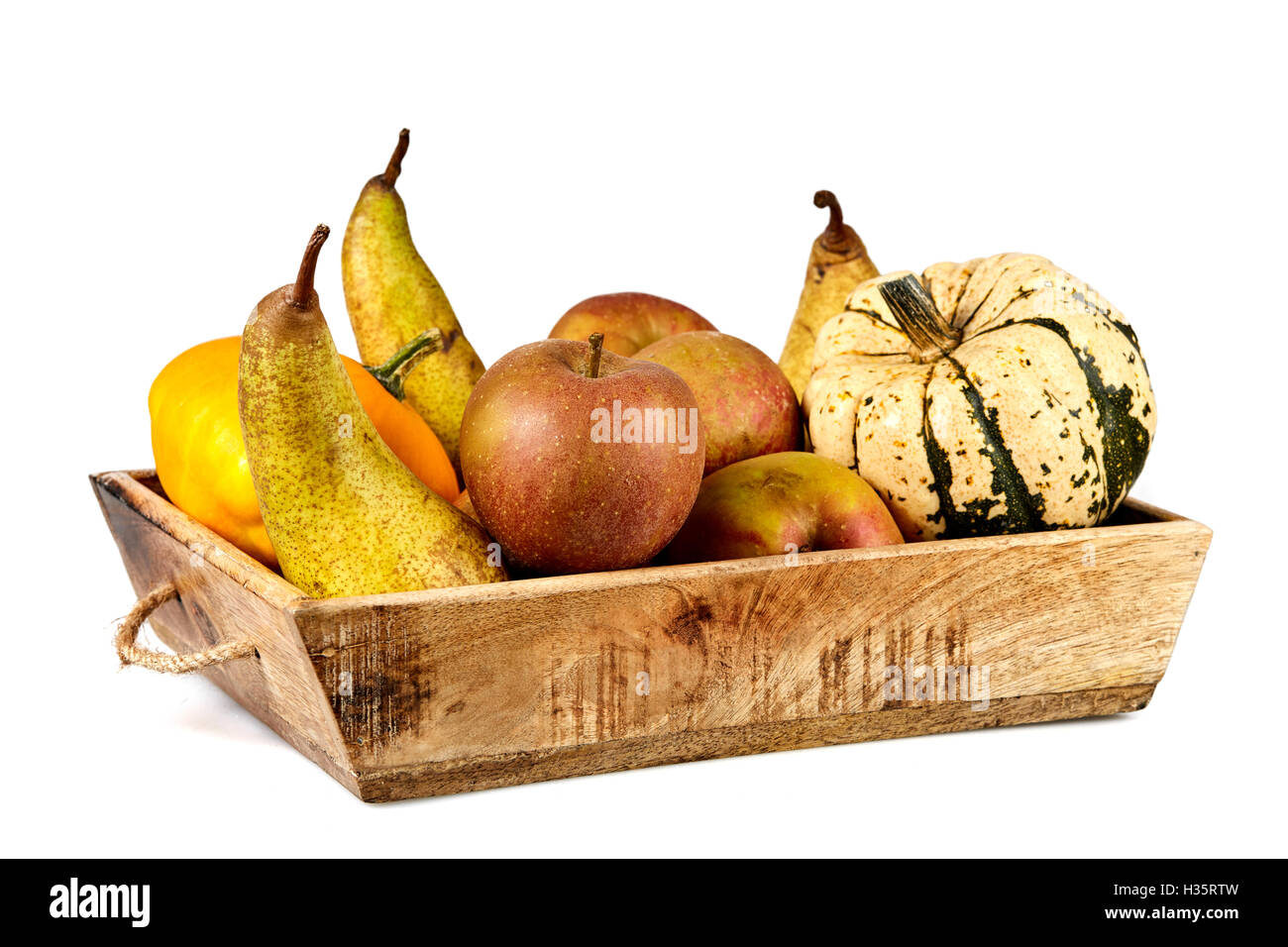 Isolato cesto pieno di frutti in autunno con le mele, pere e zucca Foto Stock