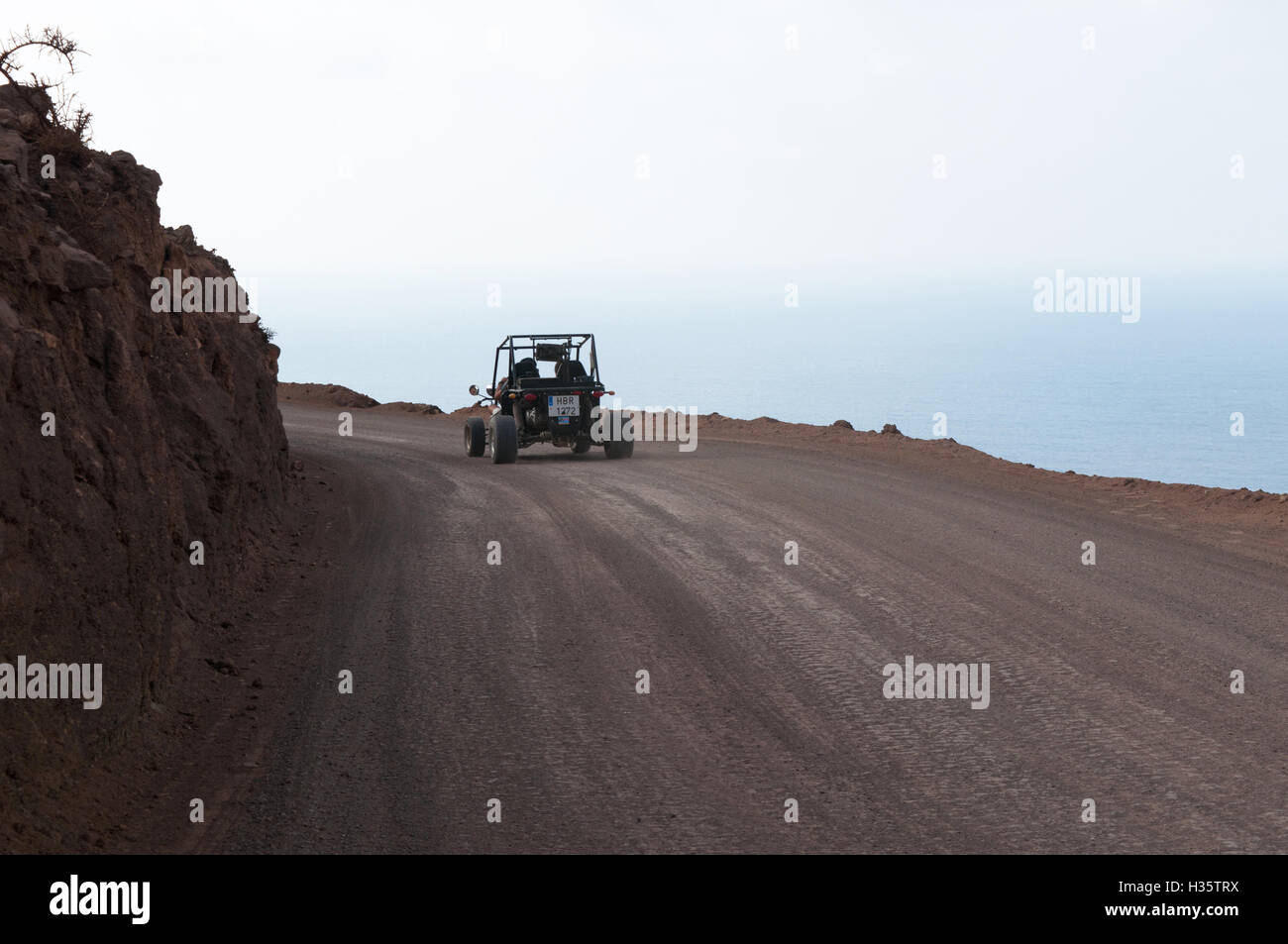 Fuerteventura Isole Canarie, Nord Africa, Spagna: un dune buggy sullo sporco e tortuosa strada sulla scogliera a Playa de Cofete spiaggia Foto Stock