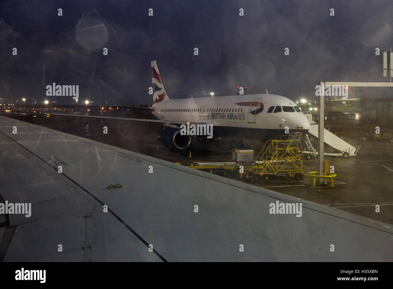 Vista attraverso una finestra di aereo a grigio di un giorno di pioggia come si prepara per il decollo DAL REGNO UNITO. Foto Stock