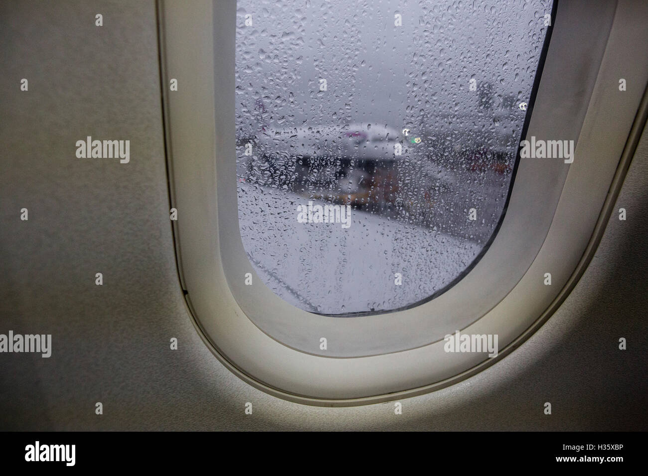 Vista attraverso una finestra di aereo a grigio di un giorno di pioggia come si prepara per il decollo DAL REGNO UNITO. Foto Stock