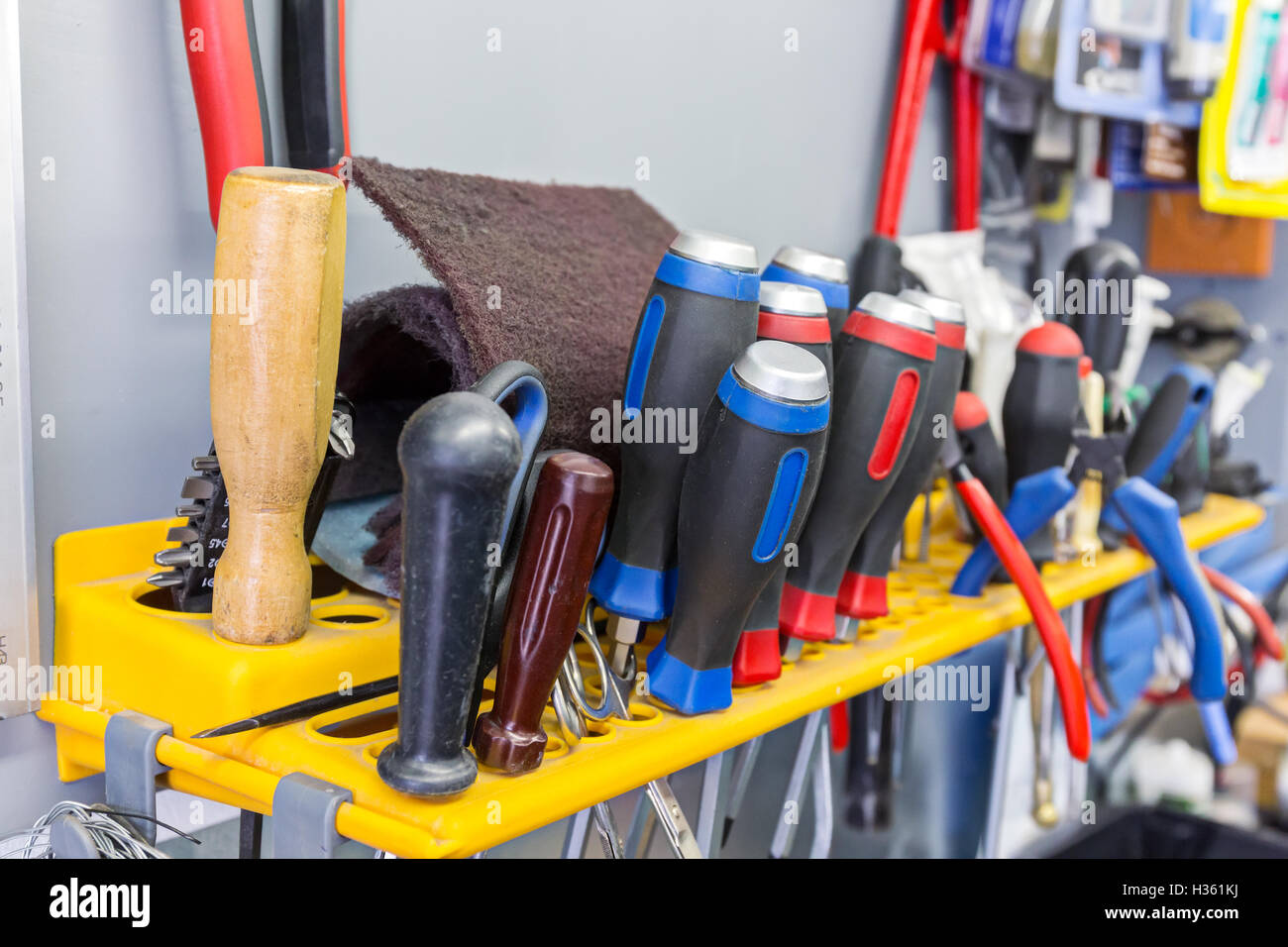 Set di strumenti di lavoro appeso su sfondo grigio Foto Stock