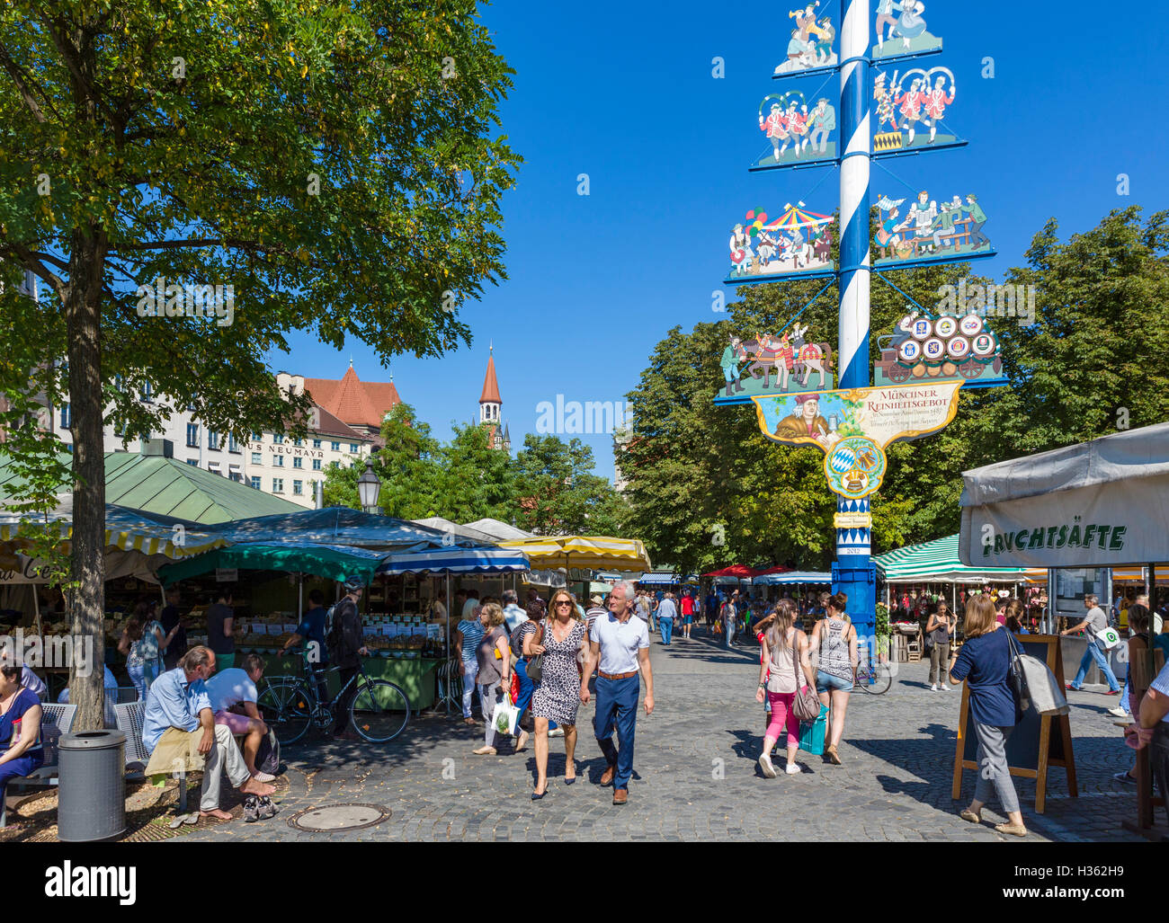 Le bancarelle del mercato nel Viktualienmarkt vicino al Maibaum (Maypole), Monaco di Baviera, Germania Foto Stock