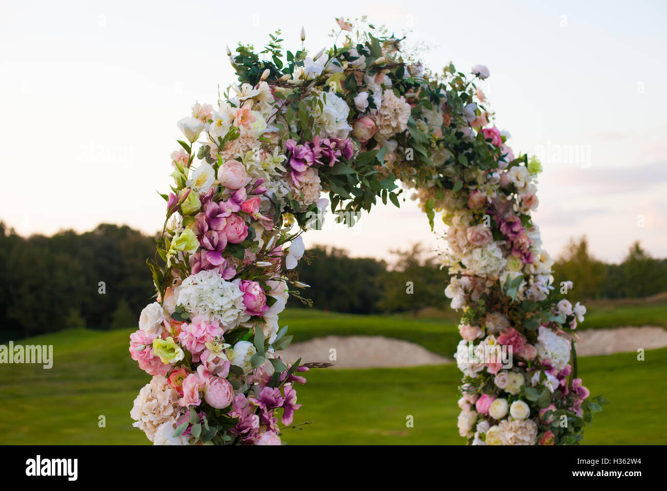 Arco floreale sul campo verde Foto Stock