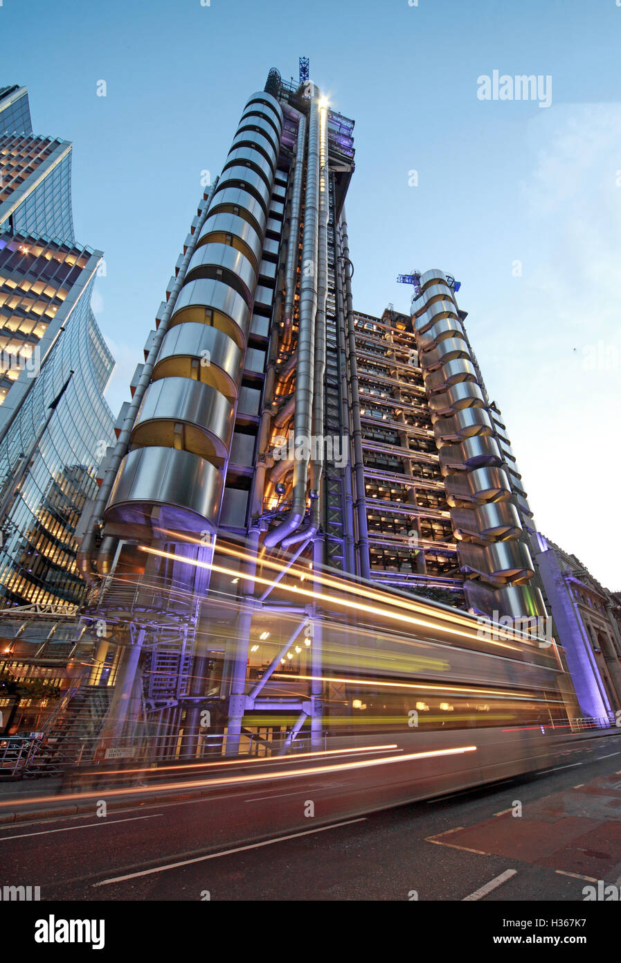 Il traffico passa Lloyd's edificio Londra al tramonto, calce St, Inghilterra Foto Stock