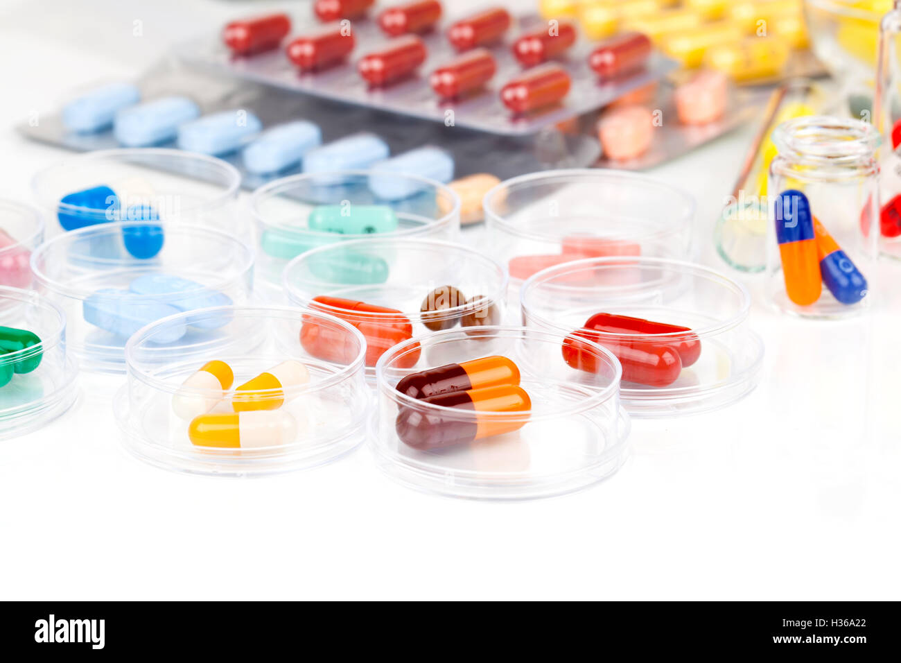 Colorate le capsule di medici in capsule di Petri. Concetto di laboratorio. Foto Stock