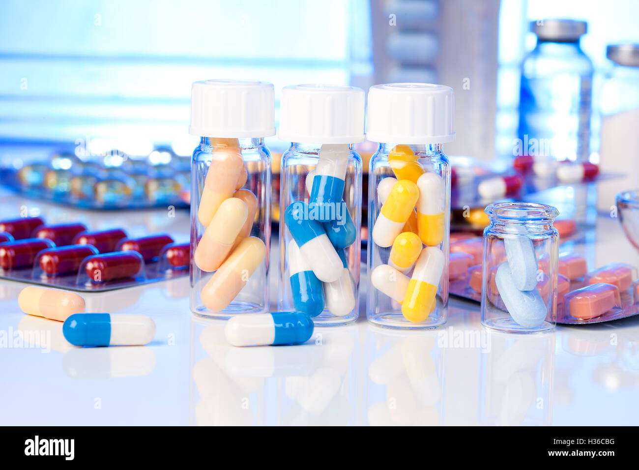Colorate le capsule di medici in bottiglia, su sfondo bianco. Foto Stock