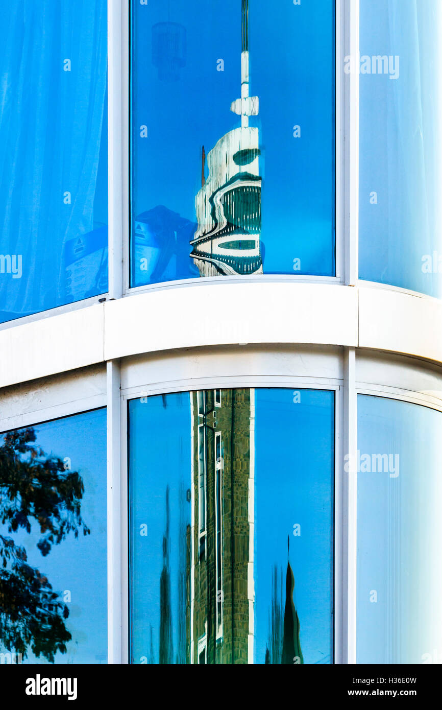 Composizione geometrica del cielo blu brillante e alto edificio si riflette nella curva facciata di vetro di Londra edificio di appartamenti Foto Stock