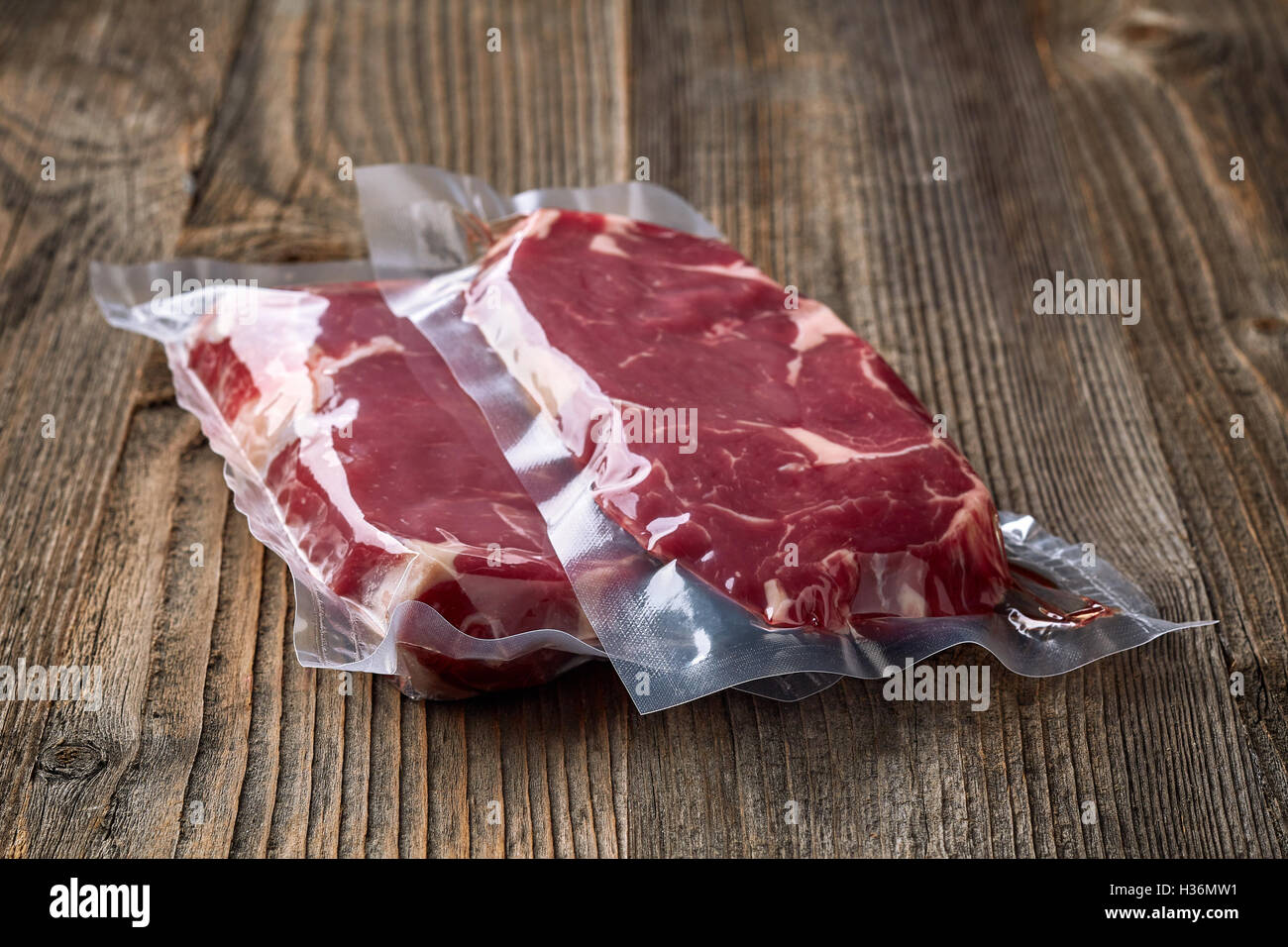 Carni bovine fresche bistecca per sous vide la cottura su un tavolo di legno Foto Stock