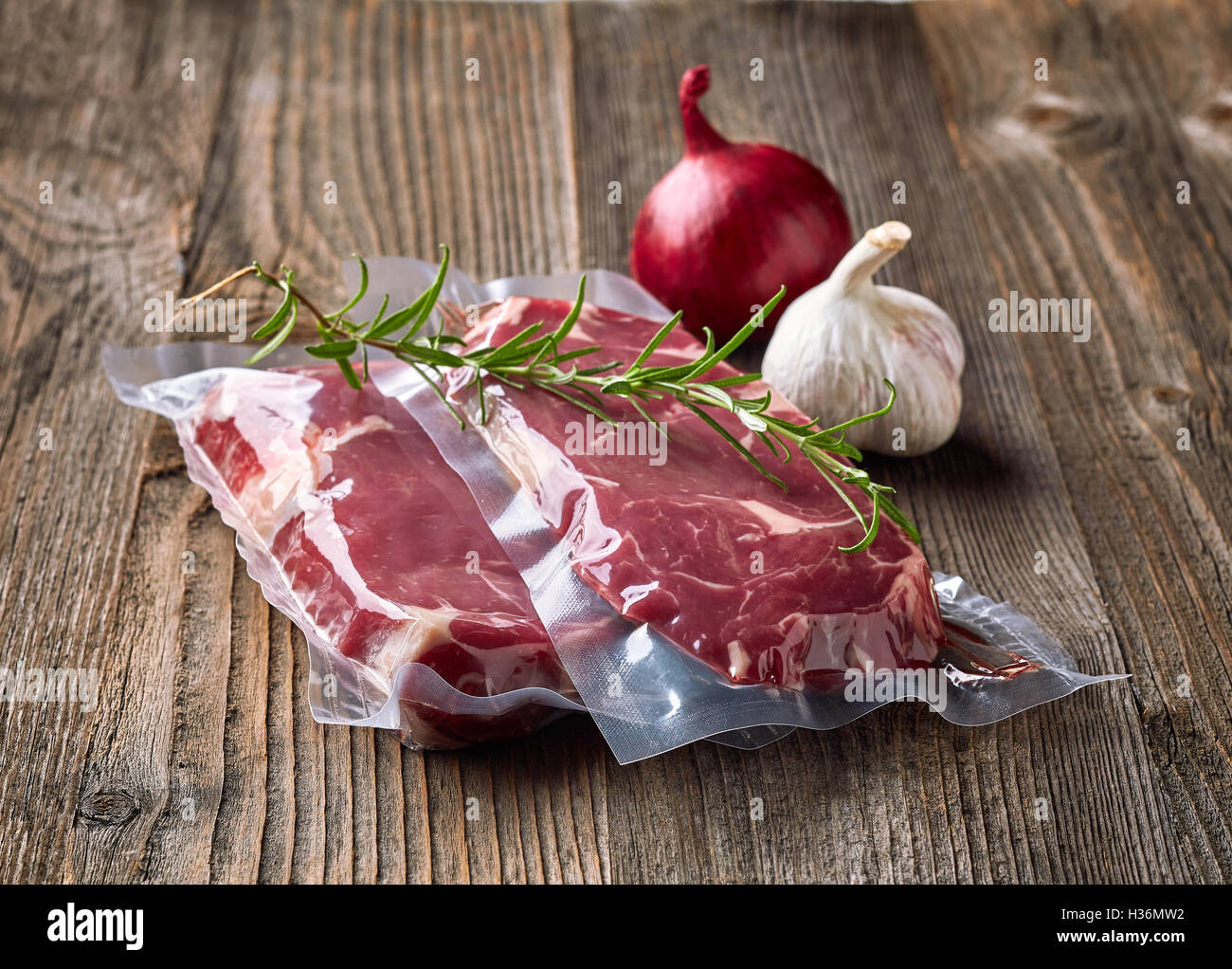 Carni bovine fresche bistecca per sous vide la cottura e spezie sul tavolo di legno Foto Stock