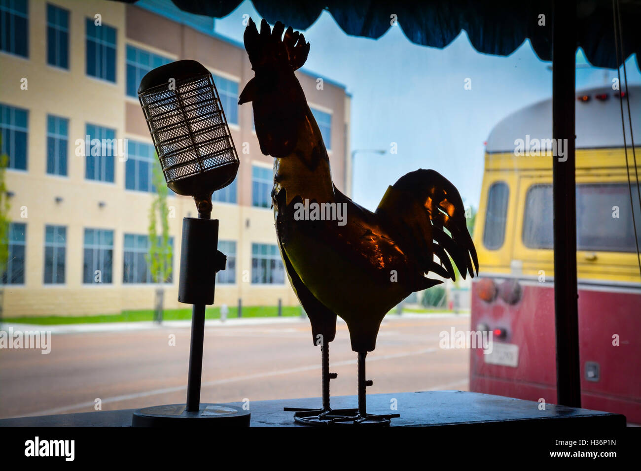 Un stagliano iconico rockabilly gallo scultura di metallo croons nel microfono vintage a Sun Studio, con il vecchio bus, Memphis TN Foto Stock