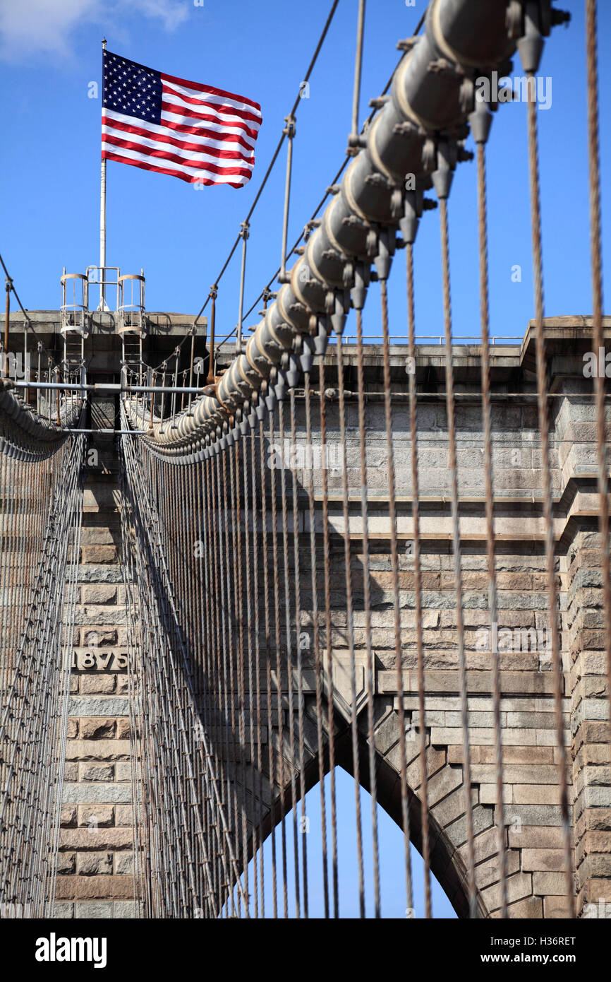 Cavi di sospensione sul ponte di Brooklyn con bandiera americana sulla torre del ponte in background.New York City,USA Foto Stock