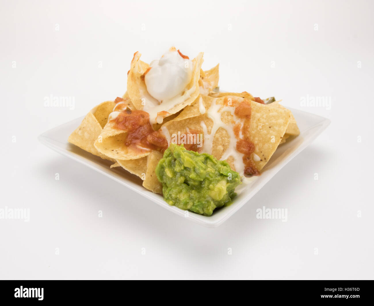 Nachos con queso, salsa guacamole e isolato su bianco Foto Stock