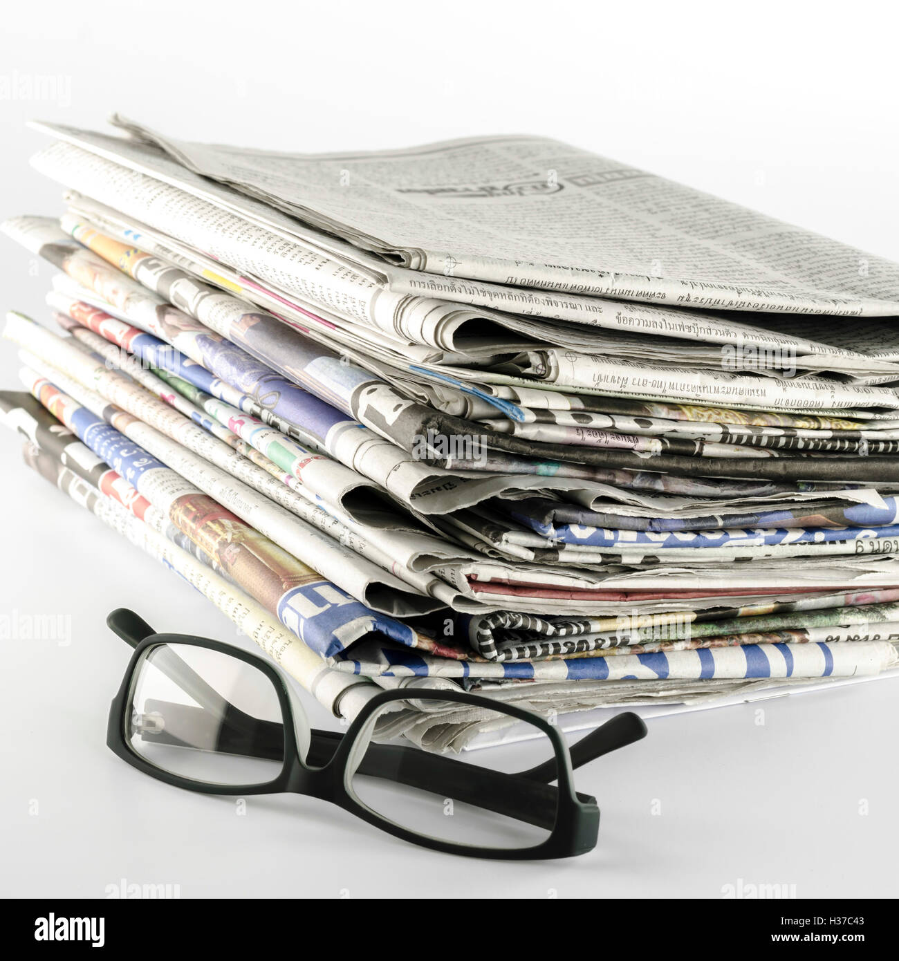 Pila di giornale con gli occhiali Foto Stock