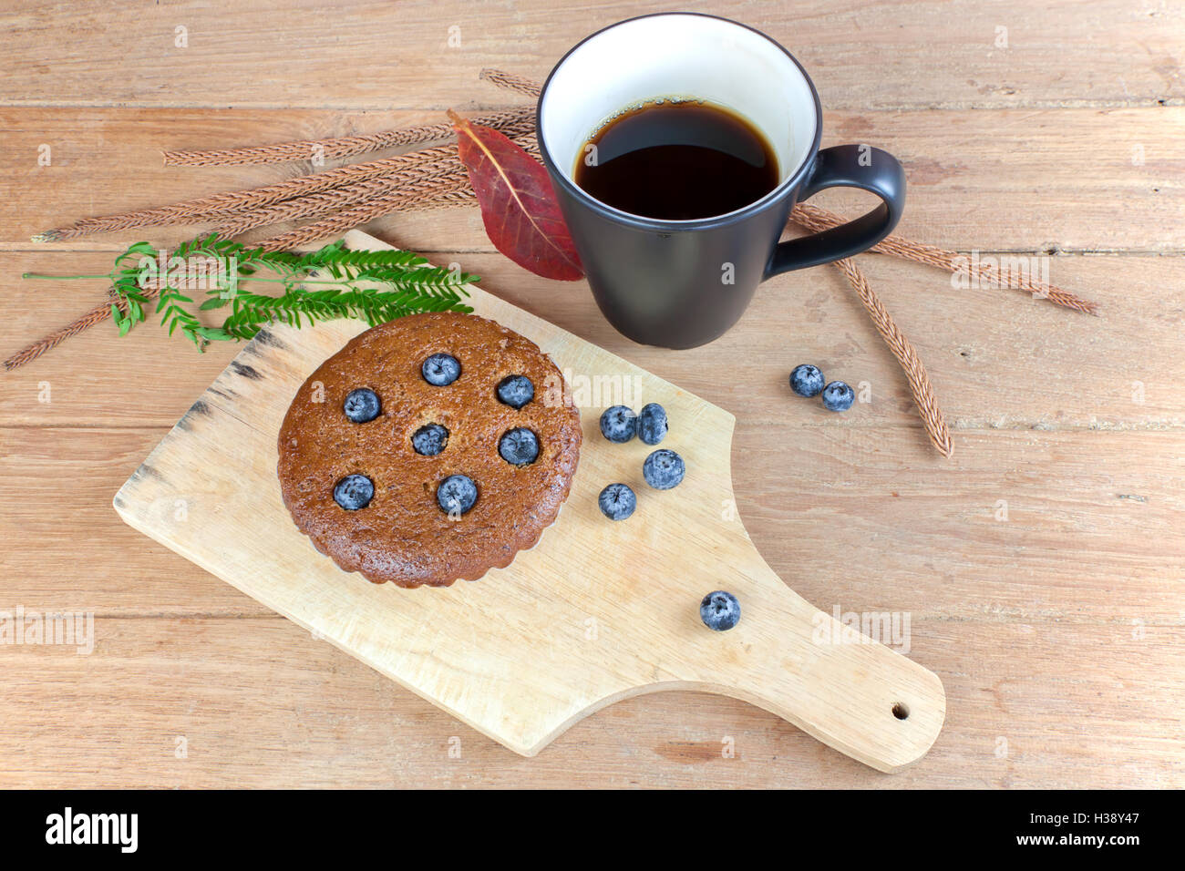 Muffin alla banana mirtilli e caffè caldo con per la prima colazione sul tavolo di legno. Foto Stock