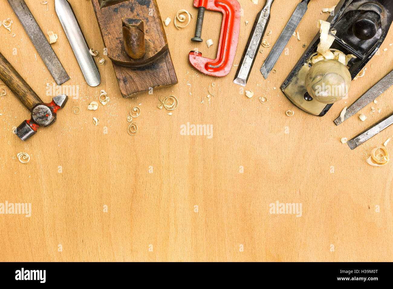 Banco da lavoro di falegnameria con strumenti diversi su sfondo di legno Foto Stock