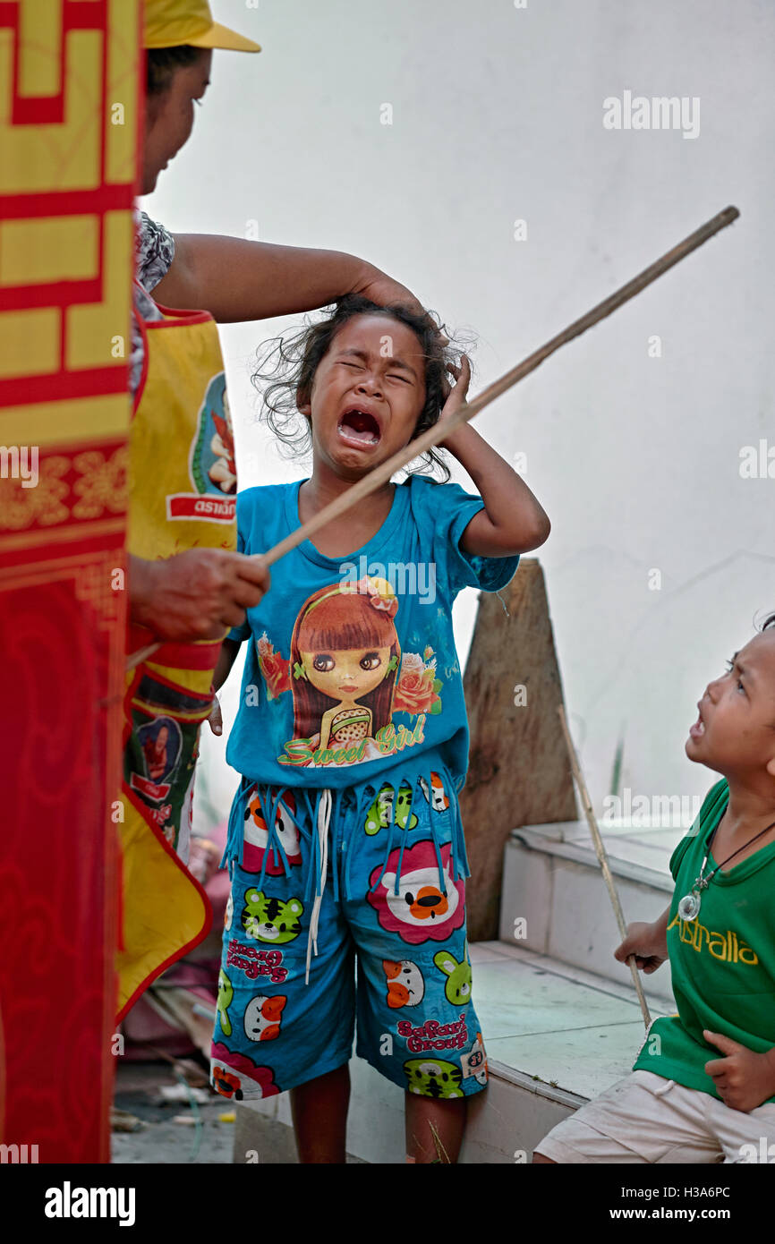 Madre scolding sua figlia gridando e brandendo un bastone. Thailandia SUDEST ASIATICO Foto Stock