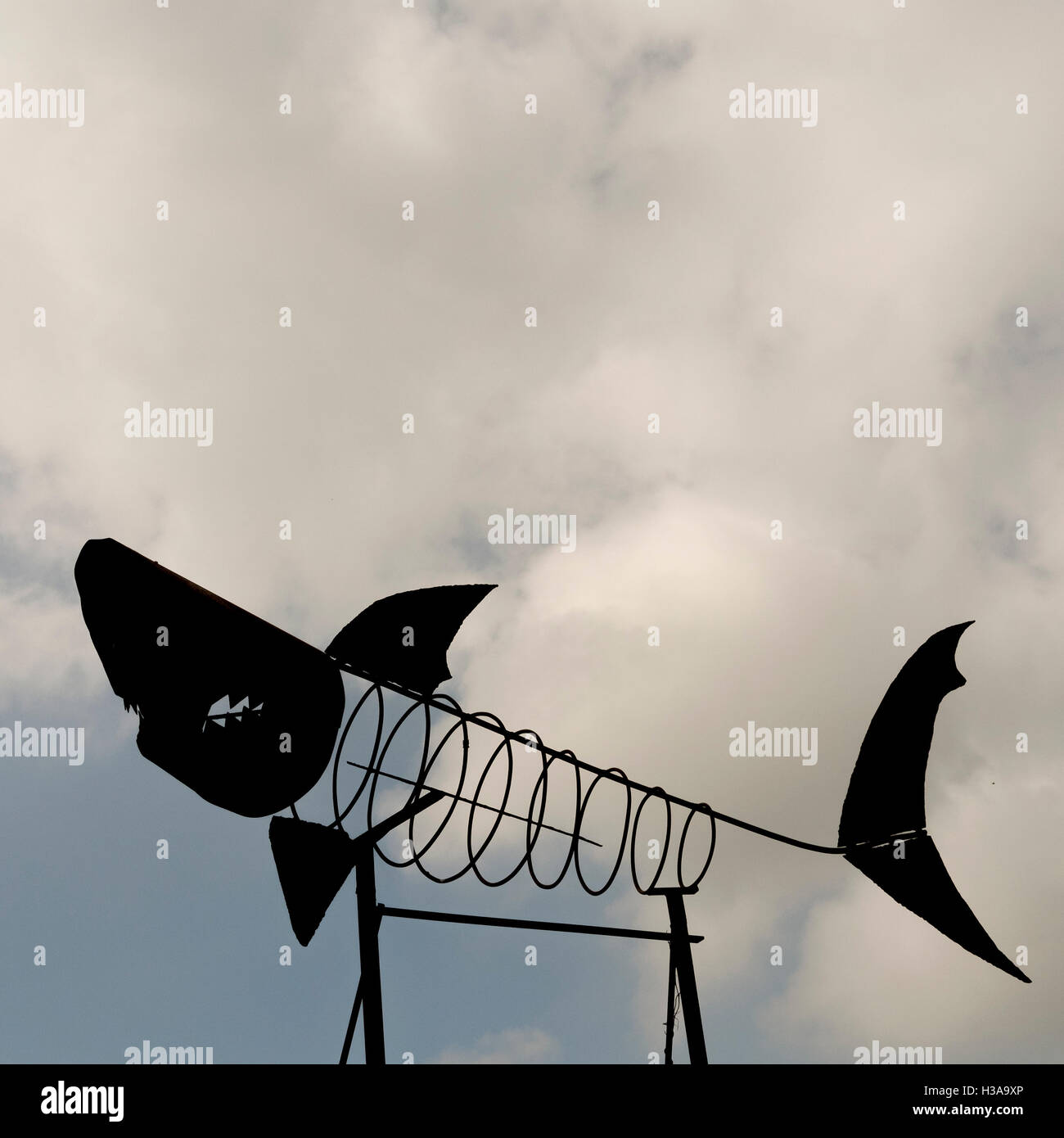 Una scultura di metallo in forma di uno scheletro di squalo contro un cielo nuvoloso Foto Stock