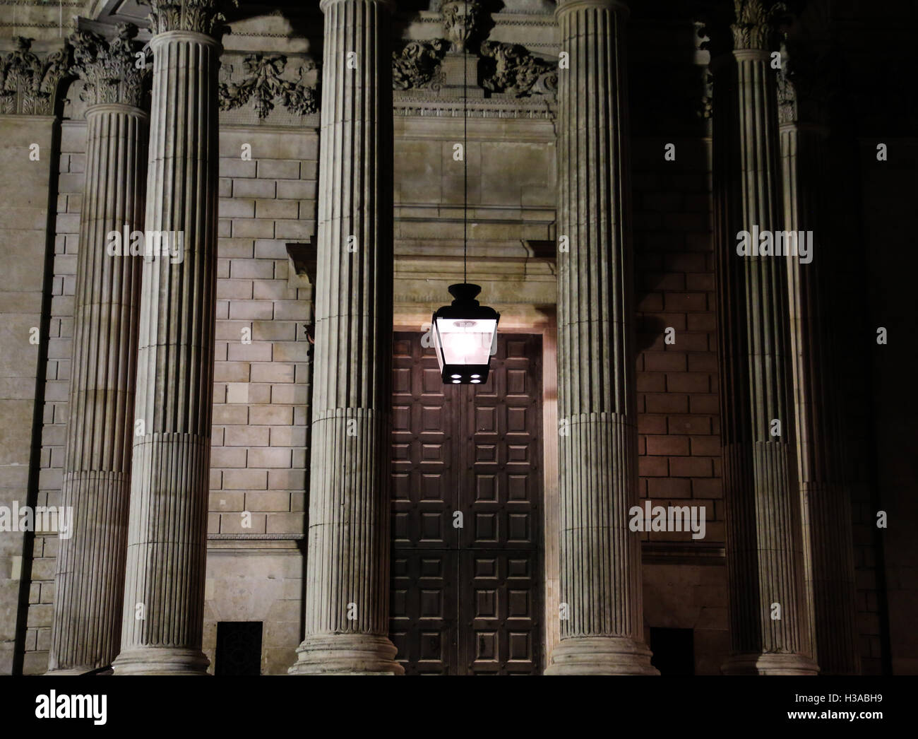 Le colonne all'ingresso per la famosa cattedrale di San Paolo a Londra, moodily accesa e scattata di notte. Foto Stock