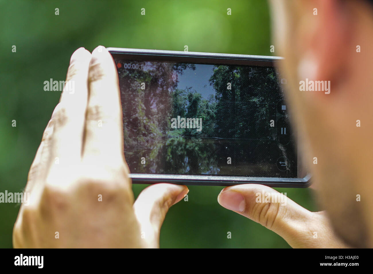 Giovane turista sta usando il suo smartphone per catturare e immagine e trovare la sua posizione in montagna Foto Stock