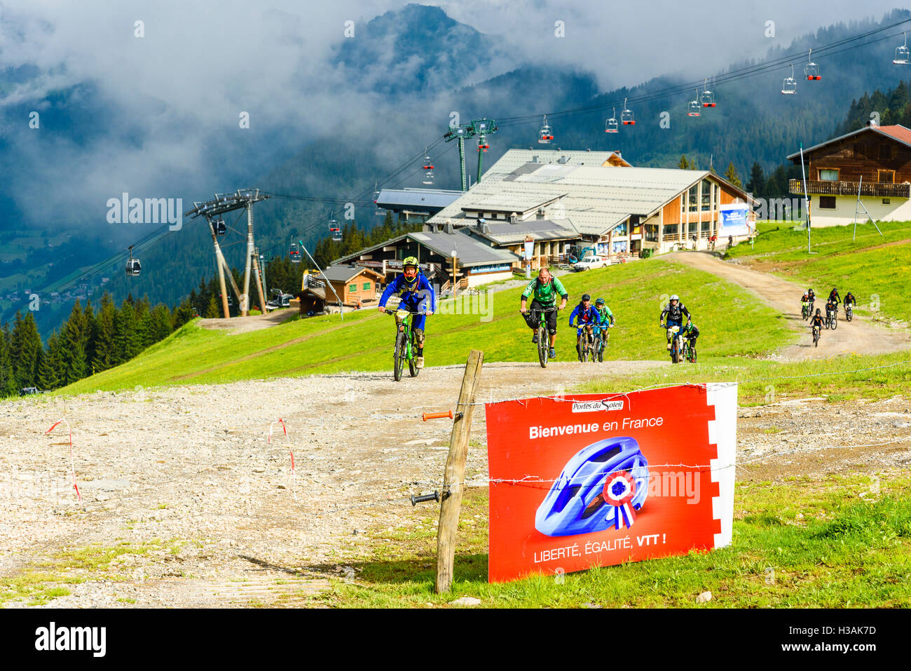 I piloti si avvicinano il confine franco-svizzero durante il passaggio"Portes du Soleil 2016 MTB mountain bike evento Foto Stock
