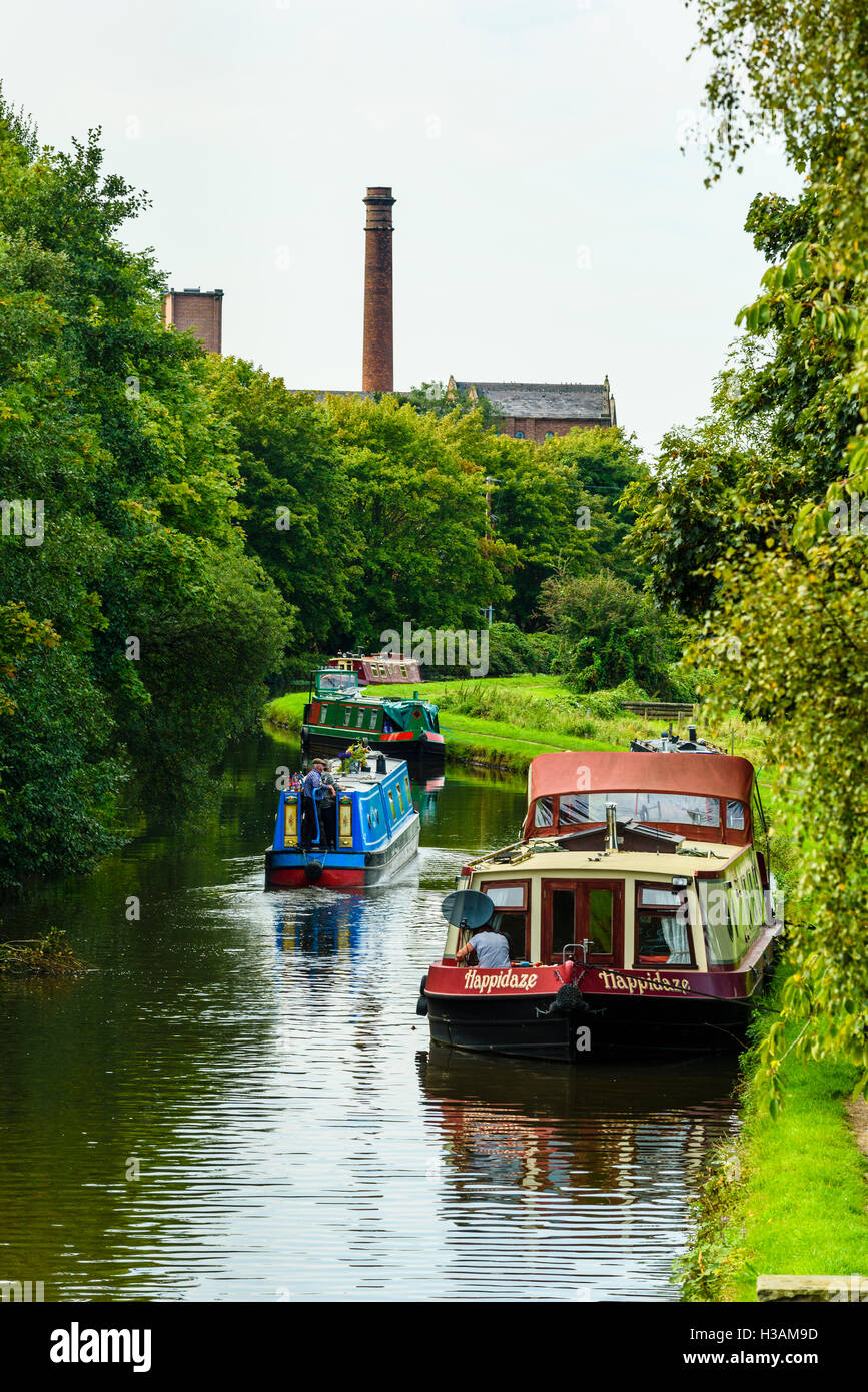 Narrowboats sul Leeds e Liverpool Canal appena fuori Burscough in West Lancashire England Regno Unito guardando verso Ainscough Mill Foto Stock