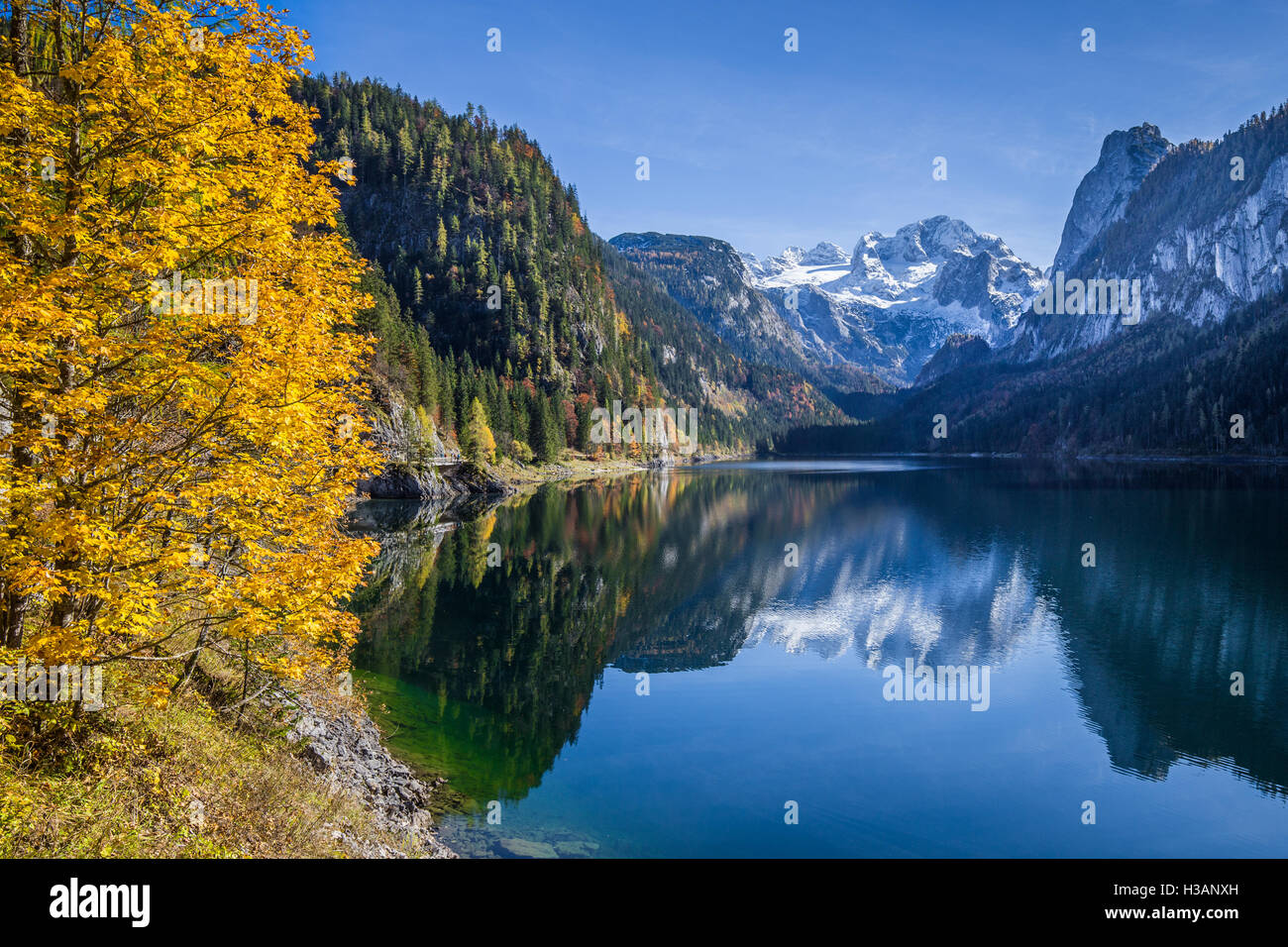 Dachstein mountain summit riflettendo in crystal clear Gosausee montagna in autunno, regione del Salzkammergut, Austria superiore, Austria Foto Stock