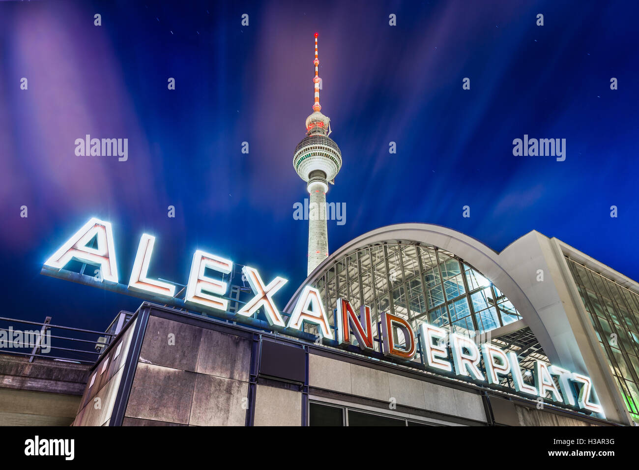 Classic ampio angolo di vista di Alexanderplatz insegna al neon con la famosa torre della televisione e la stazione ferroviaria di notte Berlino, Germania Foto Stock