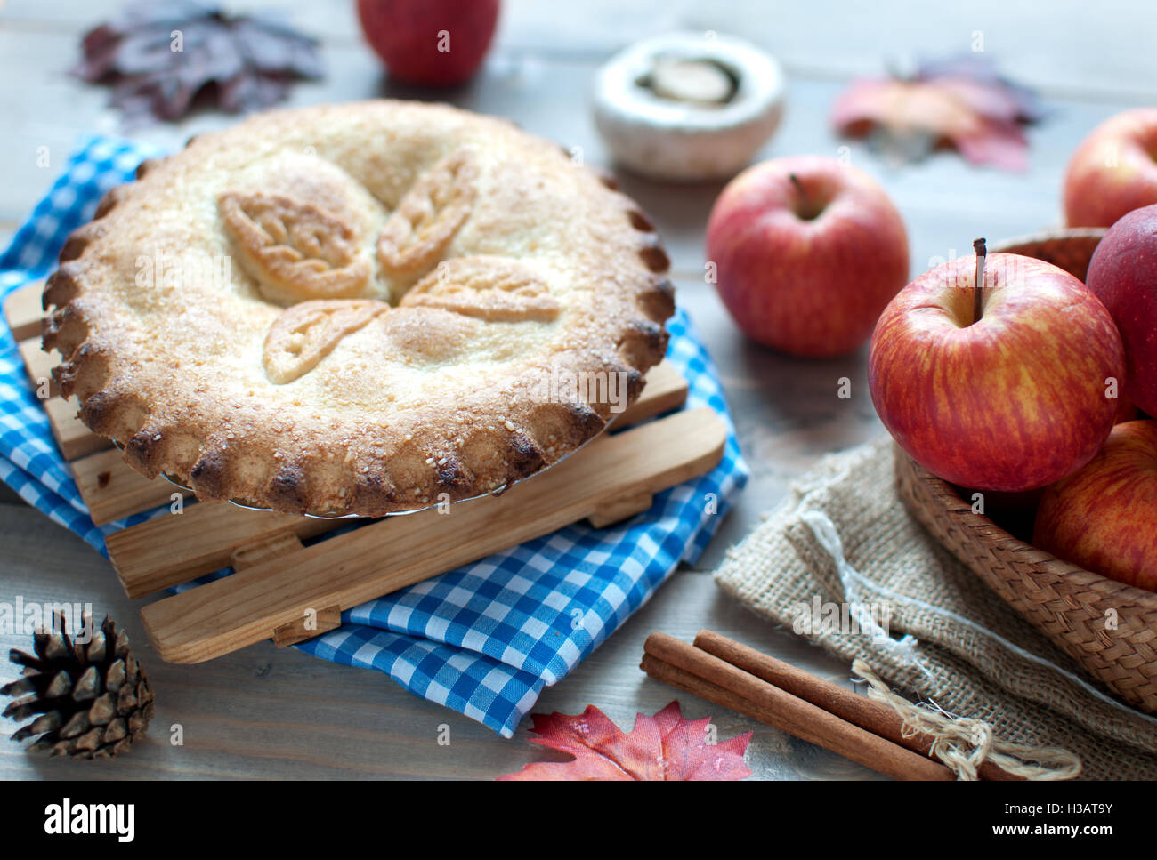 Torta di mele con frutta ingredienti Foglie di autunno e cinammon bastoni su una tavola di legno Foto Stock