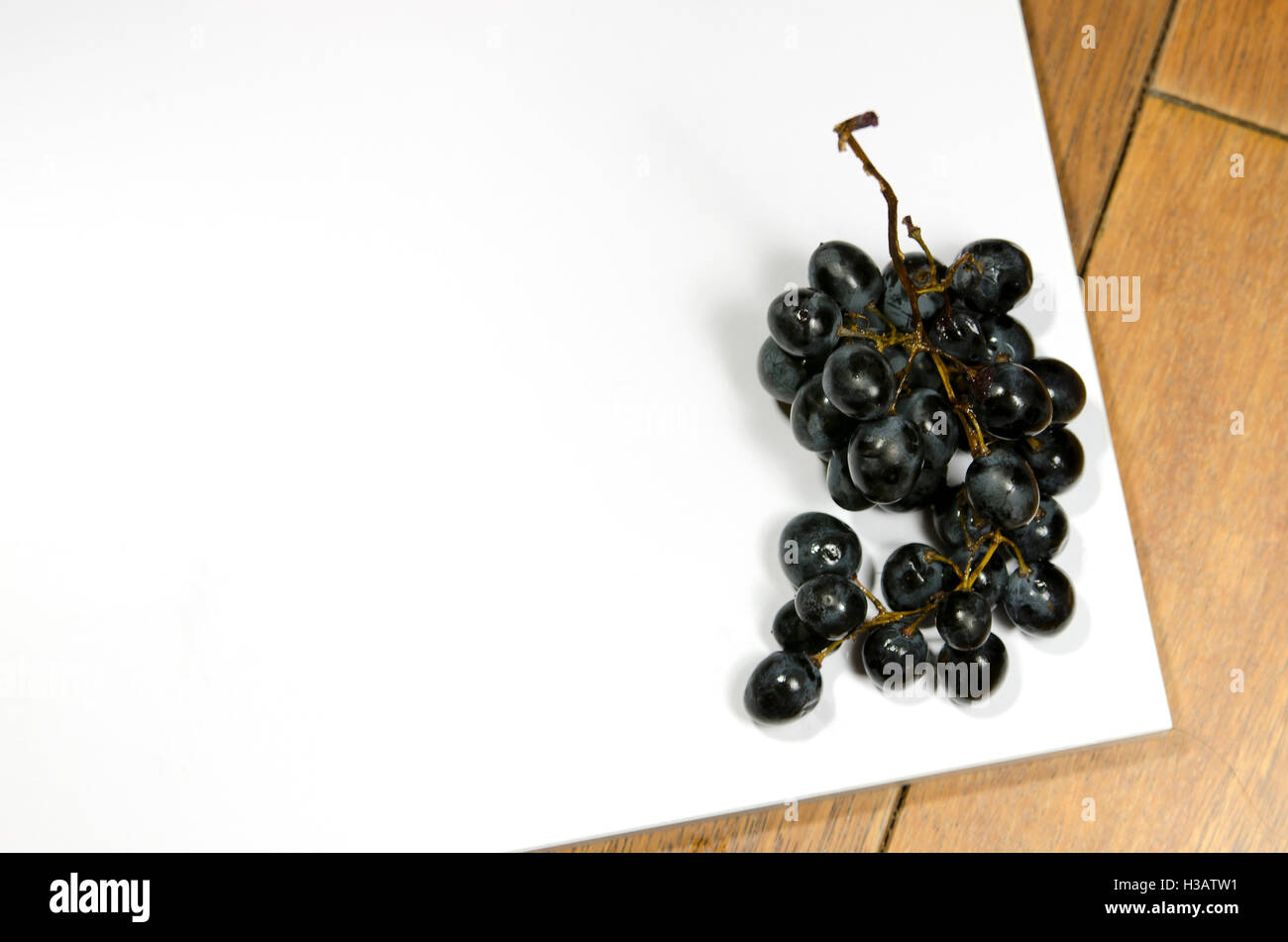 Uve rovinate su tavola Foto Stock