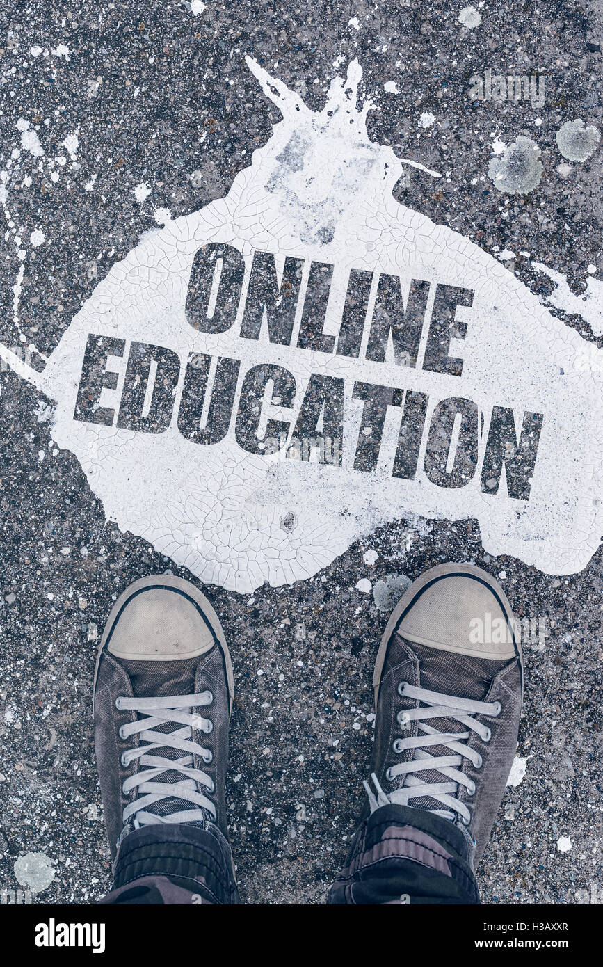 Online il concetto di istruzione con i giovani studenti di sesso maschile che indossa indossato sneakers permanente sulla strada sopra il titolo. Foto Stock