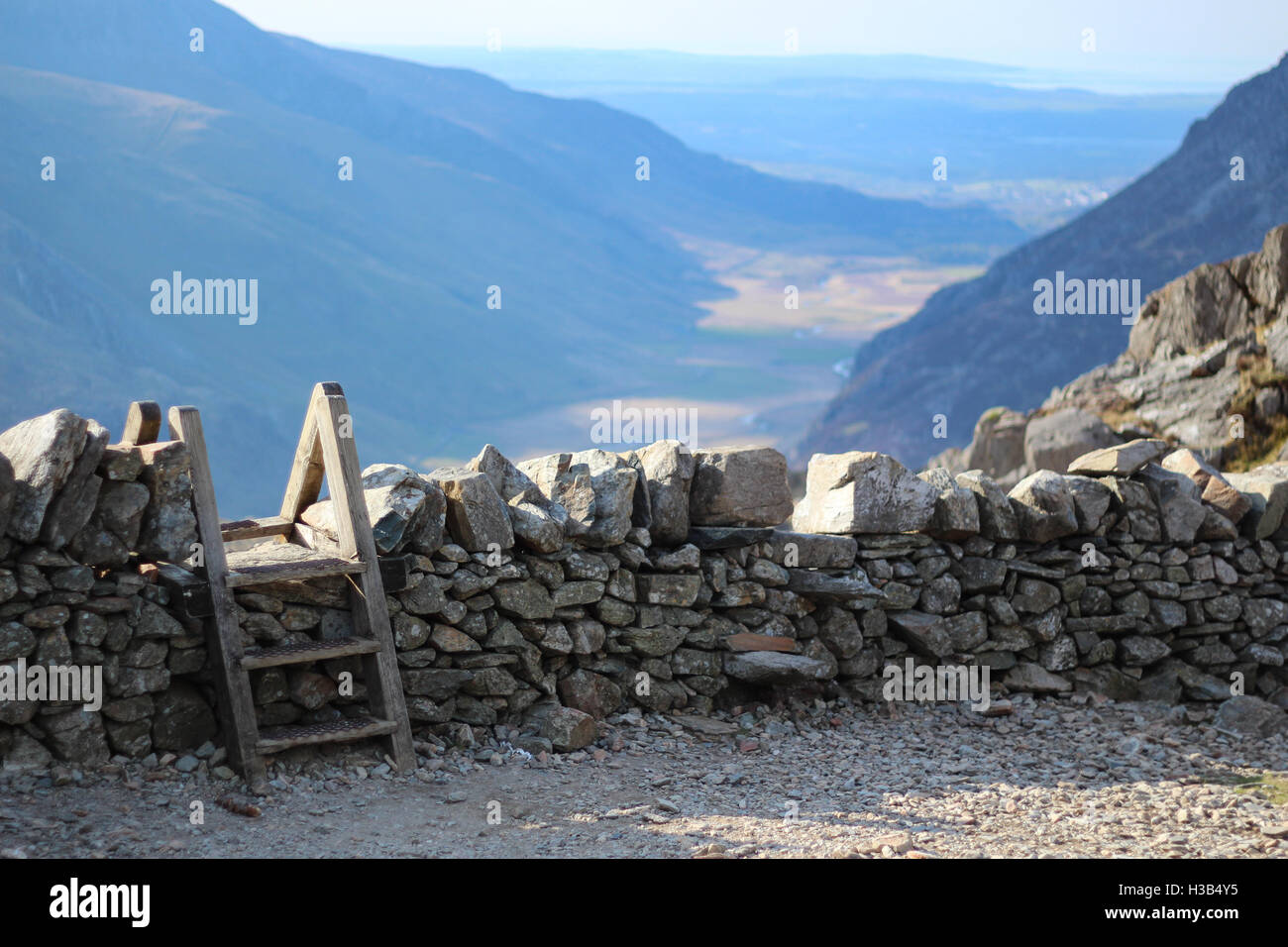 Stile oltre il muro di pietra in Snowdonia, Wales, Regno Unito Foto Stock