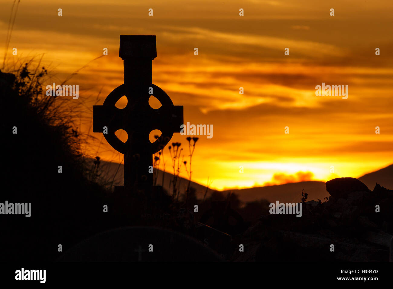 Silhouette della Croce celtica al tramonto sulla penisola di Dingle nella Contea di Kerry, Irlanda Foto Stock