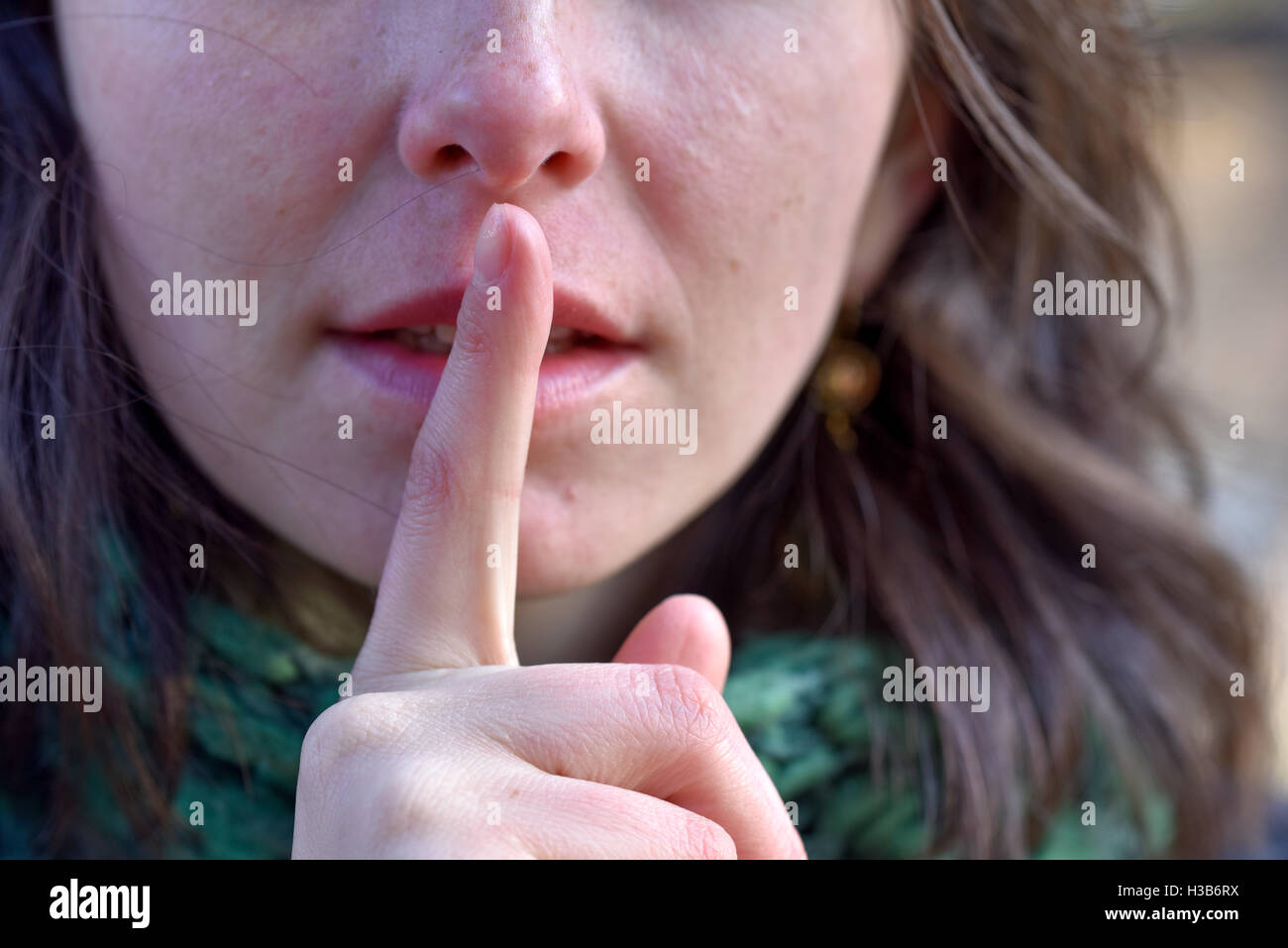 Ragazza mettere un dito per le sue labbra di silenzio Foto Stock