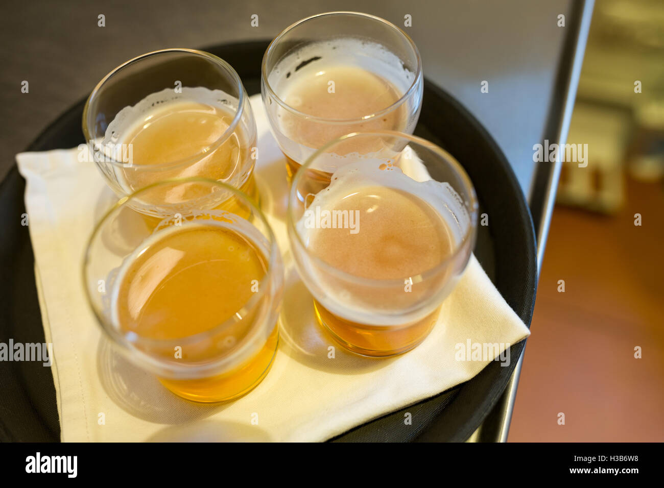 Quattro bicchieri da birra servite sul vassoio al bancone bar Foto Stock