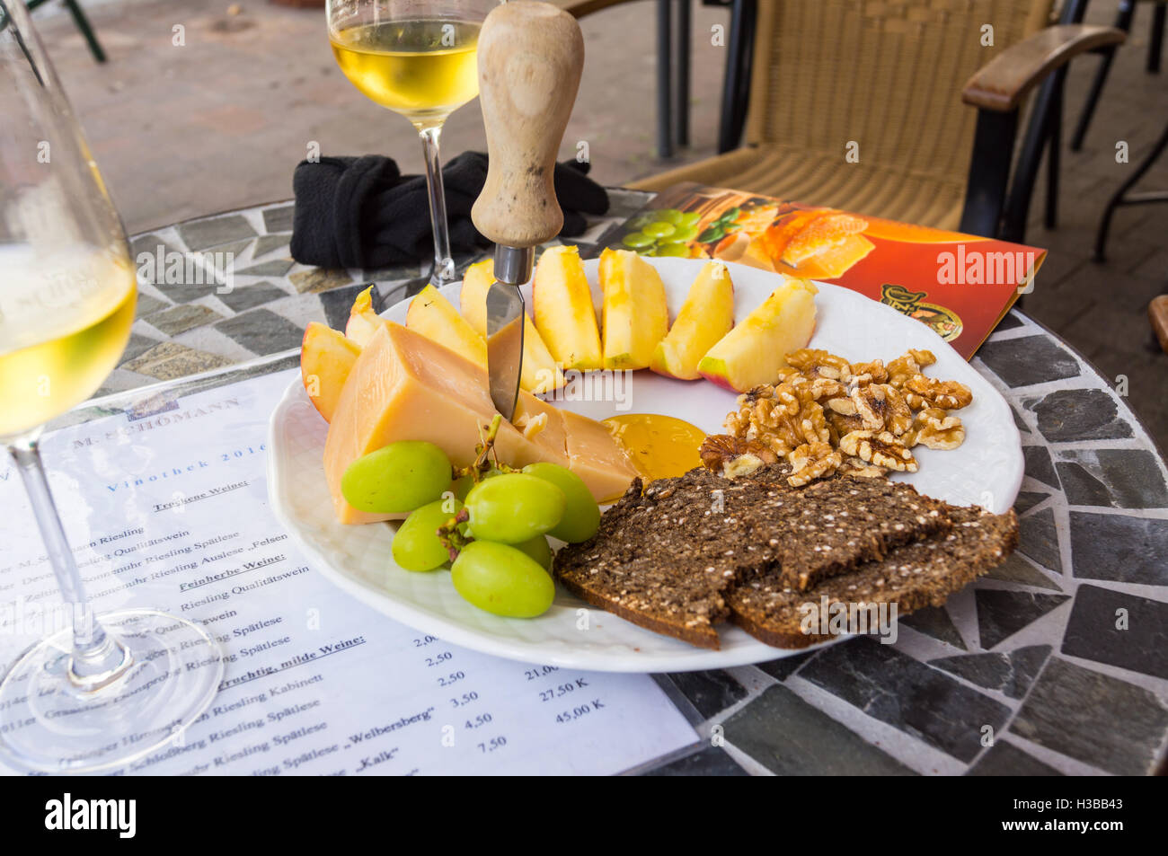 Una piastra del lituano 'Dziuga' formaggio e pane di segale con un bicchiere di vino Riesling, Weingut Schömann, Zeltingen Mosel, Germania Foto Stock