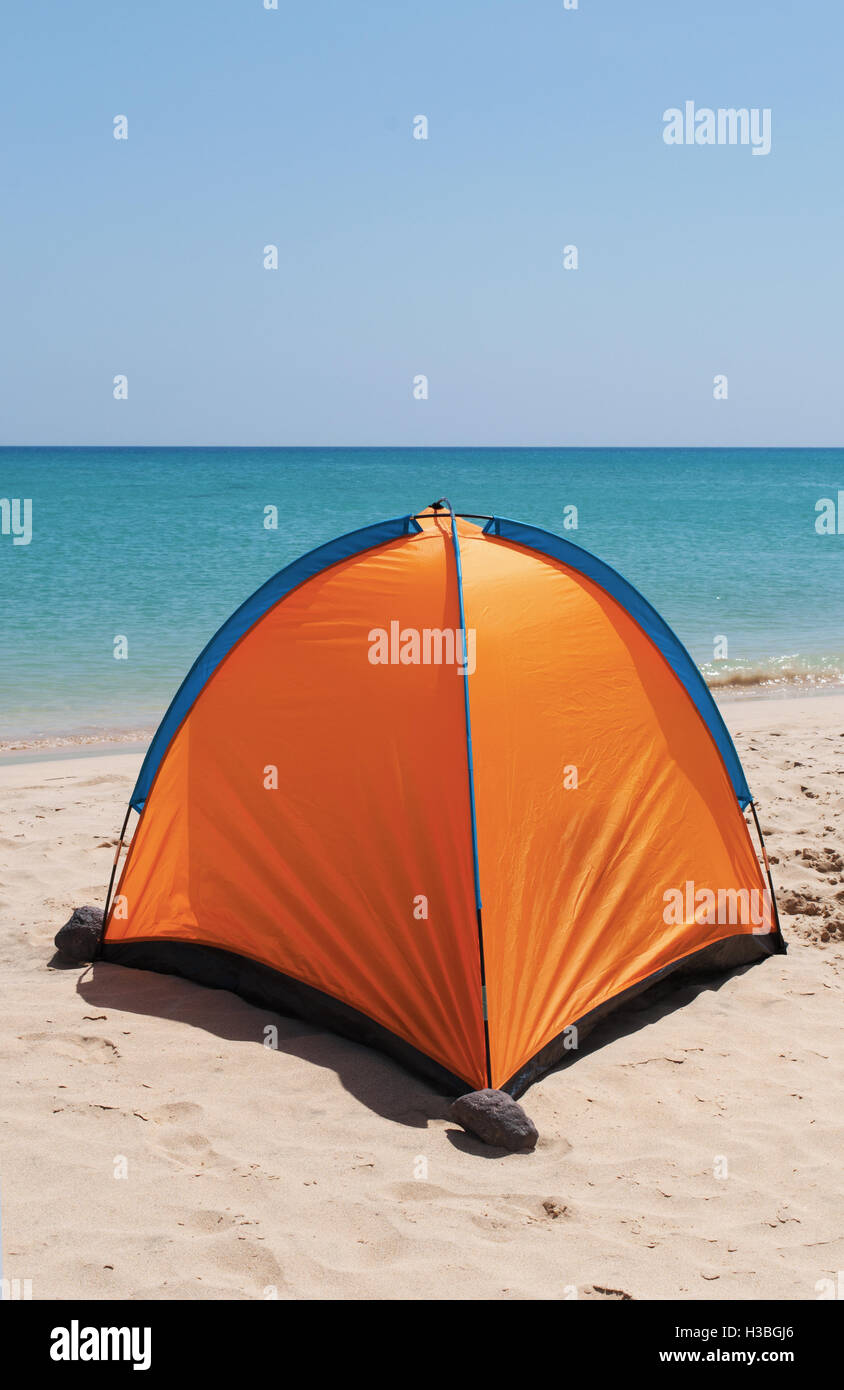 Fuerteventura Isole Canarie, Nord Africa, Spagna: un arancio tenda su una spiaggia di sabbia bianca con acqua cristallina sullo sfondo Foto Stock