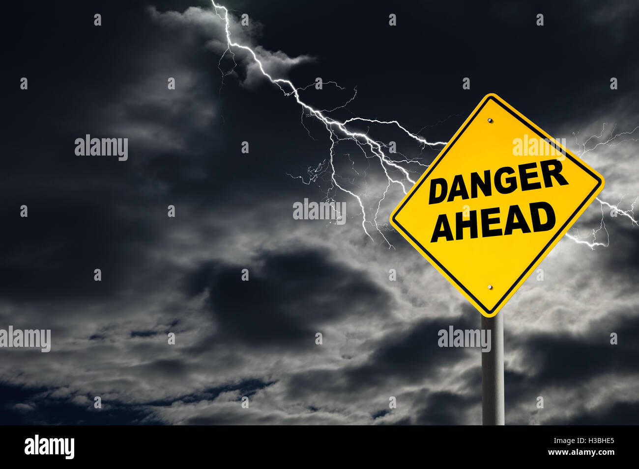 Pericolo imminente cartello stradale contro un oscuro, nuvoloso e cielo tonante. Dal punto di vista concettuale di avvertimento di pericolo imminente. Foto Stock