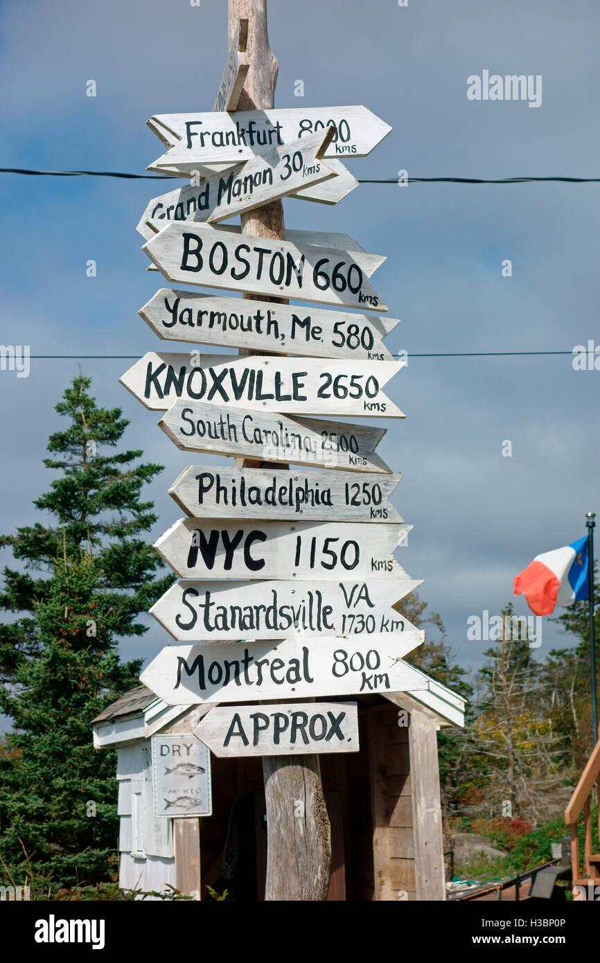 Un albero o palo di indicazioni che fanno riferimento a varie città con il numero di miglia contrassegnati sull'Isola Lunga in Nova Scotia, Canada Foto Stock