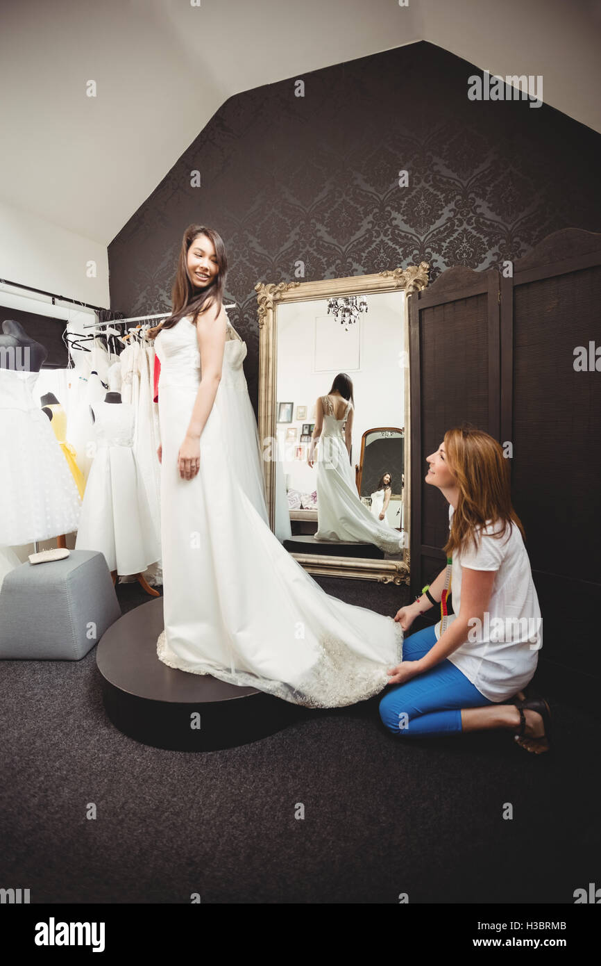 Donna cercando in abito da sposa con il contributo di designer creativo Foto Stock