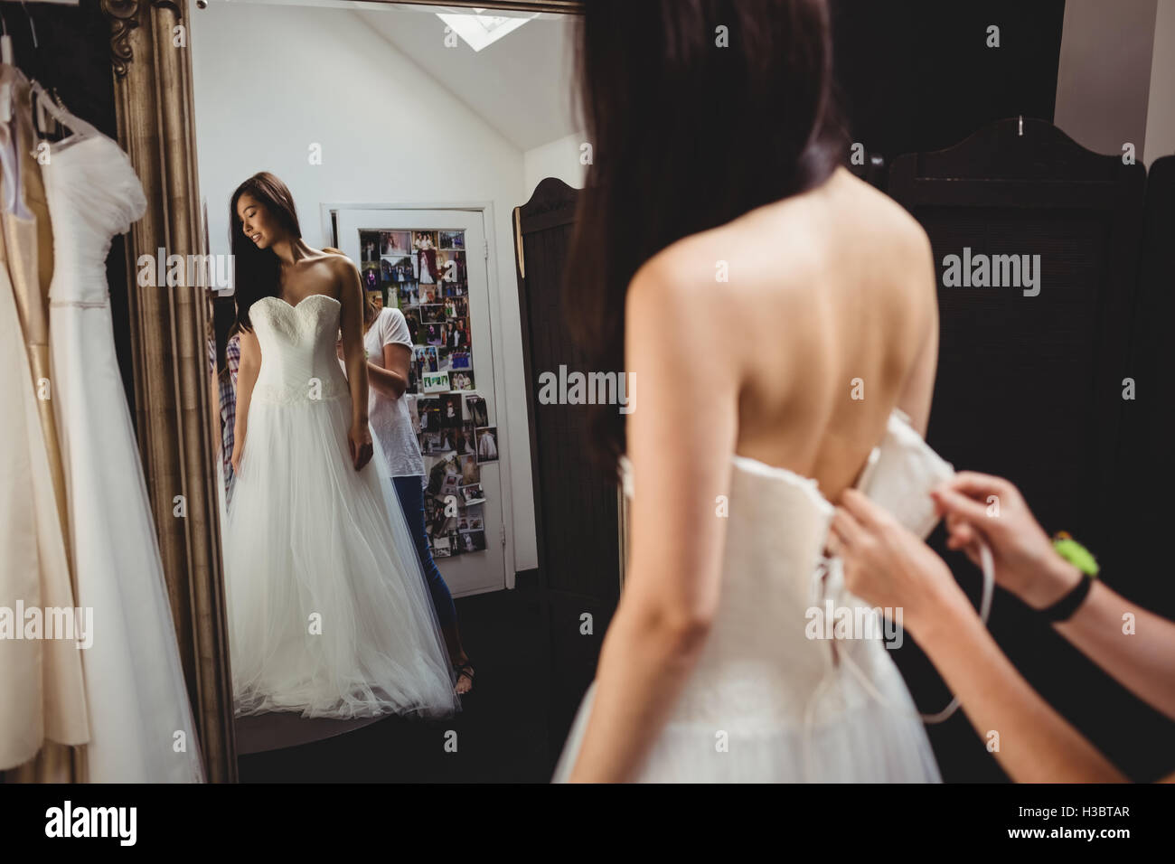Donna cercando in abito da sposa con il contributo di designer creativo Foto Stock