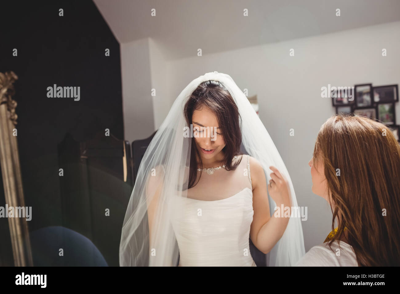Donna cercando in abito da sposa con il contributo di designer creativo Foto Stock
