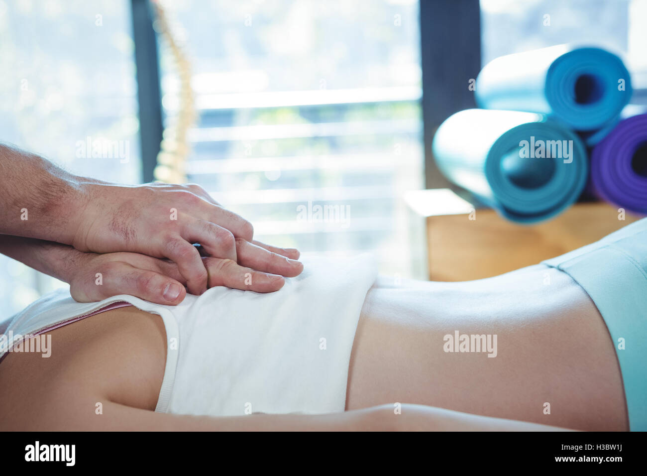 Fisioterapista maschio dando massaggio alla schiena al paziente di sesso femminile Foto Stock